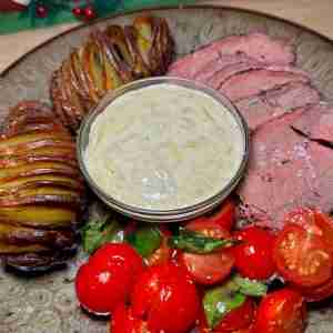 Steak, hassleback potatoes, cherry tomatoes, and a dip